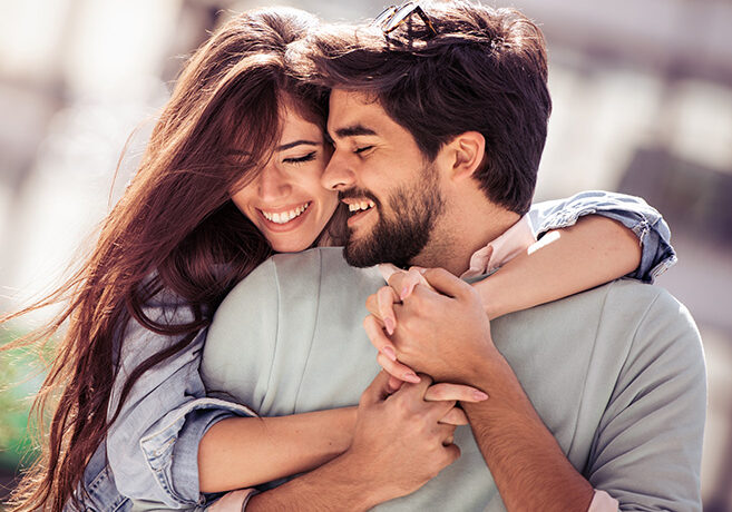 Happy young couple having fun outdoors and smiling.